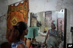 Maricelys Colás posa en su cuarto en la ruinosa mansión de la calle Villegas. Esta jubilada de 64 años vive en la casa con su madre de 85 años desde hace 59 años. (Foto AP/Ramón Espinosa)