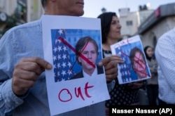 Palestinos muestran imágenes tachadas en rojo del secretario de Estado de Estados Unidos, Antony Blinken, en protesta por su visita a Ramallah, en la ocupada Cisjordania.