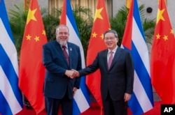 En esta fotografía publicada por la agencia de noticias Xinhua, el primer ministro cubano Manuel Marrero Cruz, a la izquierda, es recibido por su homólogo chino Li Qiang. (Zhai Jianlan/Xinhua vía AP)