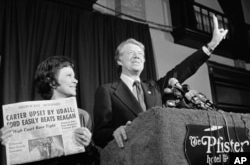 Jimmy Carter hace la señal de la victoria junto a su esposa, Rosalynn Carter, después de ganar la primaria presidencial demócrata de Wisconsin, en 1976. (AP Foto/Paul Shane, Archivo)