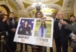 Joni Ernst, republicana por Iowa, sostiene un cartel con fotografías de las víctimas del asesinato Sarah Root y Laken Riley.