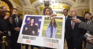 Joni Ernst, republicana por Iowa, sostiene un cartel con fotografías de las víctimas del asesinato Sarah Root y Laken Riley.