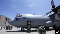 Miembros de la Fuerza Aérea Ecuatoriana posan para fotos con el avión Hércules donado por Estados Unidos a Ecuador para misiones militares, en el aeropuerto de Cotopaxi tras el acto de entrega, en Latacunga, Ecuador, el 25 de marzo de 2024.