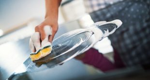 Una persona limpia la vitrocerámica en la cocina.