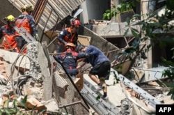 Esta fotografía tomada por la Agencia Central de Noticias de Taiwán el 3 de abril de 2024 muestra a trabajadores de emergencia ayudando a un sobreviviente tras ser rescatado de un edificio dañado en la ciudad de Nuevo Taipei, después de que un gran terremoto azotara Taiwán.