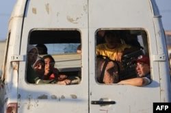 Palestinos desplazados junto a sus pertenencias viajan en una camioneta que circula por el campamento de Al-Bureij, en el centro de la Franja de Gaza, el 2 de junio de 2024. (Foto de Eyad BABA / AFP)