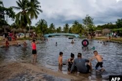 Cubanos disfrutan de la playa en Mayabeque. YAMIL LAGE / AFP