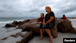 Una señora y su nieto miran el clima nublado en la plata de Saint Pete, en Florida, el domingo 4 de agosto.