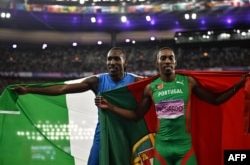 El medallista de plata Pedro Pichardo (derecha), compitiendo por Portugal, y el medallista de bronce, Andy Díaz Hernández, por Italia, celebran después de la final de triple salto masculino en los Juegos Olímpicos de París 2024. (Ben STANSALL / AFP)