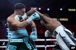 Erislandy Lara golpea a Danny García en la pelea por el título de peso mediano, el sábado 14 de septiembre, en Las Vegas. (Foto AP/John Locher)