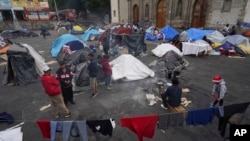 Migrantes se reúnen en un campamento de tiendas de campaña instalado en la plaza de la parroquia católica Santa Cruz y La Soledad, en el barrio de La Merced de la Ciudad de México, el 26 de diciembre de 2023. (Foto AP/Marco Ugarte, Archivo)