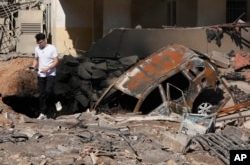 Un hombre camina sobre escombros en el lugar de un ataque aéreo israelí en los suburbios del sur de Beirut, el domingo 29 de septiembre de 2024. (Foto AP/Hassan Ammar)