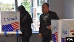 Boris Obed Ávila, (derecha) vota junto a su hija Stephanie Ávila en un centro de votación de Arlington, Virginia, el viernes 25 de octubre de 2024, luego de que ella se registrara para votar por primera vez.