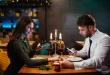 Una pareja en plena cena, cada uno con el teléfono en la mano.