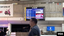 Un hombre pasa delante de un anuncio en pantalla con la foto del líder opositor Edmundo González y la frase “se busca” en el Aeropuerto Internacional Simón Bolívar de Maiquetía, el 3 de enero de 2025.