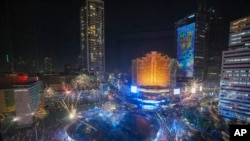 Fuegos artificiales estallan ante la vista de miles de personas congregadas en el principal distrito comercial durante las celebraciones por el Año Nuevo, en Yakarta, Indonesia, el 31 de diciembre de 2024.