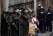 Un vendedor ambulante camina junto a miembros de la Guardia Nacional Bolivariana antes de la juramentación del presidente Nicolás Maduro para un tercer mandato, en Caracas, Venezuela, el domingo 5 de enero de 2025.