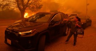 Residentes de Los Ángeles huyen ante el avance de incendio avivado por el viento