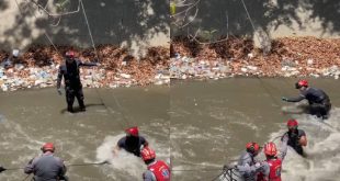 Firefighters from Caracas rescue man after falling to the Guaire River