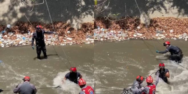 Firefighters from Caracas rescue man after falling to the Guaire River