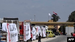 Camiones de la Media Luna Roja Egipcia cargados con ayuda hacen fila frente al cruce fronterizo de Rafah con la Franja de Gaza, el 23 de marzo de 2024.