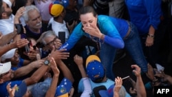 La líder de la oposición venezolana, María Corina Machado, saluda a sus seguidores durante una manifestación en Valencia, estado de Carabobo, Venezuela, el 13 de marzo de 2024.