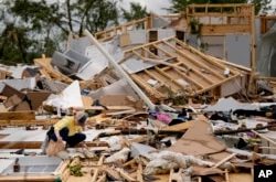 Valerie Bernhardt mira a través de los escombros en su casa dañada por una tormenta el jueves 9 de mayo de 2024 en Columbia, Tennessee, EEUU. (Foto AP/George Walker IV)