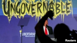 Una persona entre la multitud hace gestos mientras el expresidente y candidato presidencial republicano, Donald Trump, habla en la convención nacional del Partido Libertario en Washington, EEUU, el 25 de mayo de 2024.