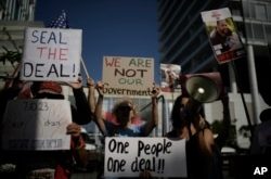 Familiares y simpatizantes de los rehenes israelíes retenidos por Hamás en Gaza sostienen carteles durante una protesta para pedir su regreso, afuera de las reuniones del secretario de Estado de EEUU, Antony Blinken, en Tel Aviv, el martes 11 de junio de 2024.