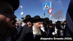 Hombres ultraortodoxos se manifiestan en contra de que los jóvenes de su comunidad sean reclutados por el ejército.