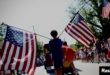 Un niño porta banderas estadounidenses a través de Barnstable Village en Cape Cod, durante el desfile anual del 4 de julio que celebra el Día de la Independencia del país, en Barnstable, Massachusetts, EEUU, 4 de julio de 2024.