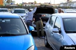 Potenciales compradores de autos inspeccionan un automóvil en La Habana, Cuba, el 25 de febrero del 2020.