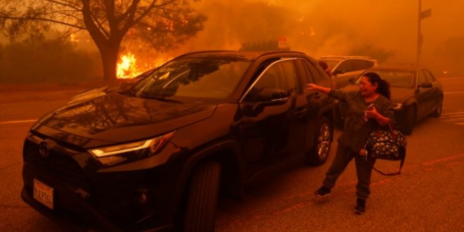 Residentes de Los Ángeles huyen ante el avance de incendio avivado por el viento