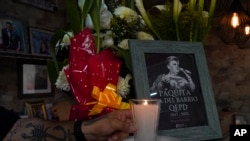 El dueño de una tienda, Carlos Torres, coloca una vela junto a un homenaje a la fallecida cantante mexicana Paquita La Del Barrio en un puesto de postres en el Mercado Martínez de la Torre en la Ciudad de México, el martes 18 de febrero de 2025.