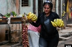 Women carry the weight of family care in a country where food is scarce. (Yamil Lage/AFP)