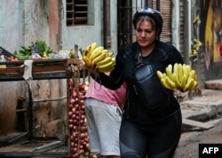 Women carry the weight of family care in a country where food is scarce. (Yamil Lage/AFP)